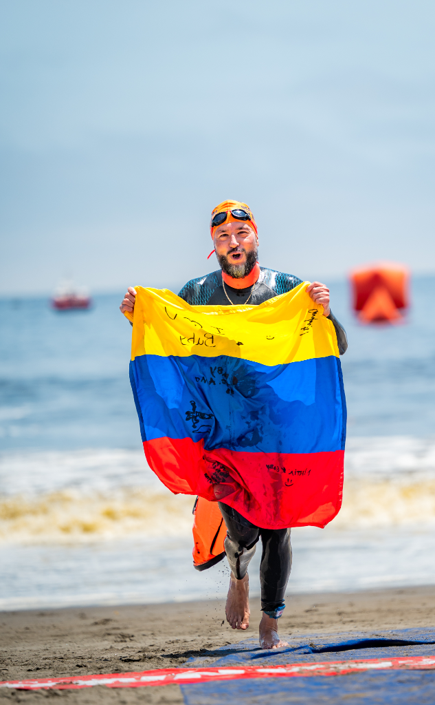 Carlos Melo corriendo con bandera Colombia en la playa